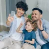 Familia feliz usando un móvil sin redes sociales en casa